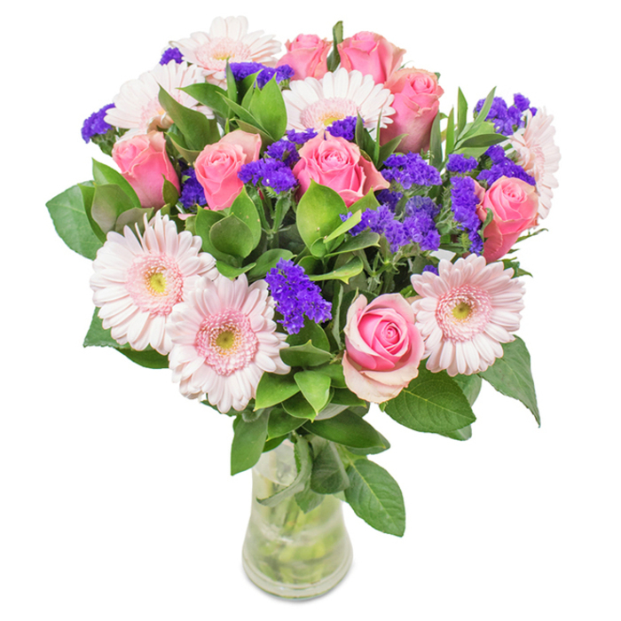 This vibrant floral bouquet from Cowley is eloquently presented in a clear glass vase, set against a crisp white background that allows every hue to flourish. At its centre bloom approximately seven to nine medium pink roses, many elegantly poised in classic spirals, some buds tightly wound while others begin to reveal their full glory. Interspersed seamlessly, five to seven pale pink gerberas showcase wide, inviting petals and paler, delicate centres-a nod to the gentle beauty seen in Cowley's own community gardens. The bouquet is accented by clusters of lively purple statice, adding excitement and depth through clusters reminiscent of flourishing spring hedgerows along Cowley Road. Robust, deep green foliage wraps the arrangement with a generous touch, enhancing the bouquet's freshness and making it an inviting, natural focal point. Clear water and long stems are visible through the streamlined vase, reinforcing the bouquet's sense of purity and craftsmanship. Perfect for Cowley birthdays, anniversaries, or milestone moments, it is an affectionate invitation to celebrate, uplift, or simply bring a piece of local floral artistry indoors.
